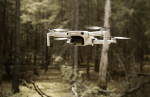 This is an image of an unmanned drone being flown in a forest.