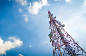 This image is looking up towards a telecommunications tower on a sunny day.