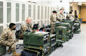 This image is of US troops utilizing technology, such as laptops and tablets, within their job.