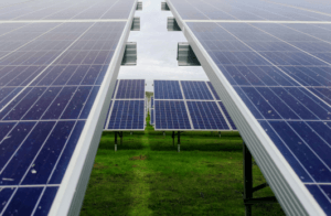 This image shows solar panels in a field. The image serves to show a way how telecommunications and renewable energy are being utilized together to address environmental concerns.